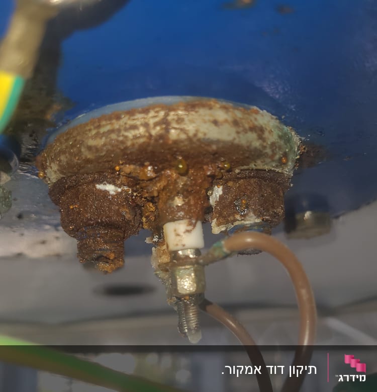 חלק תחתון של דוד שמש עם חלודה וחוטי חשמל